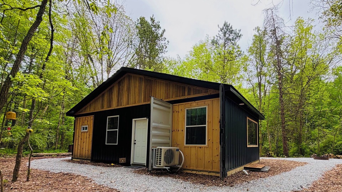 Lapeer Cabin | Beehive shipping container cabin surrounded by nature and a pond