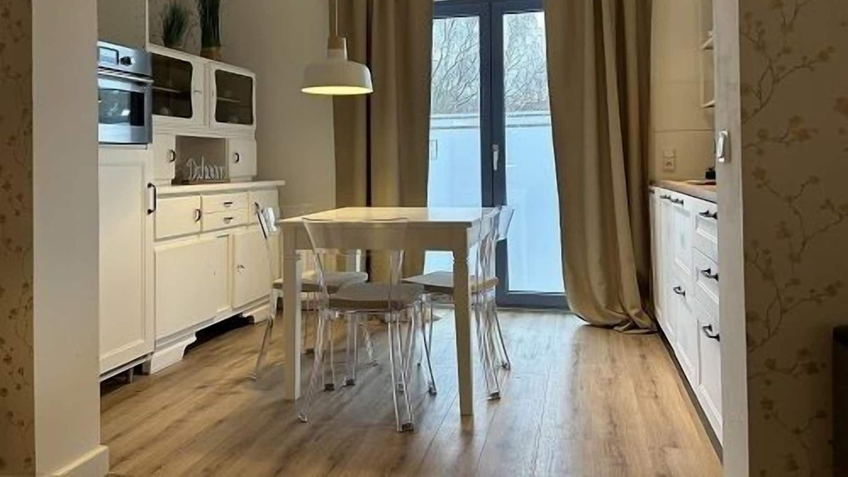 Hamburg-Barmbek Apartment | Bright apartment with a small, functional kitchen and a spacious dining area.