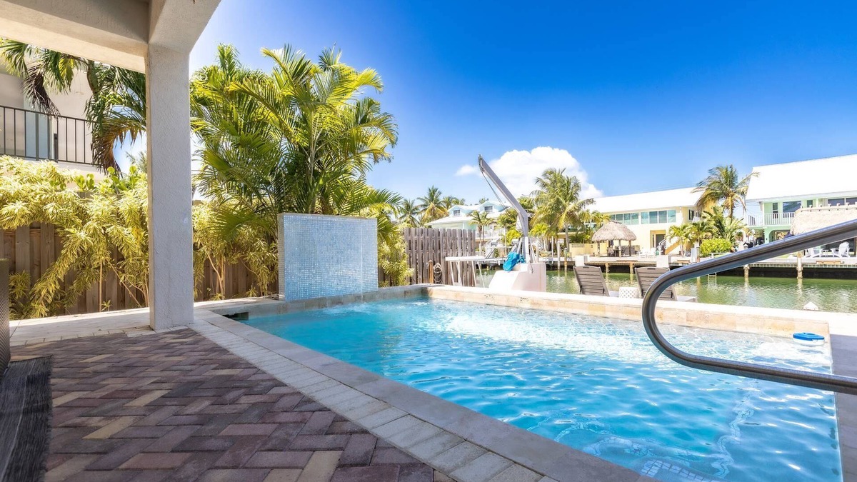 Coury House | Casa Paraiso: Discover This Charming 2BR Canal Front Duplex in KCB with Private Pool & Dockage!