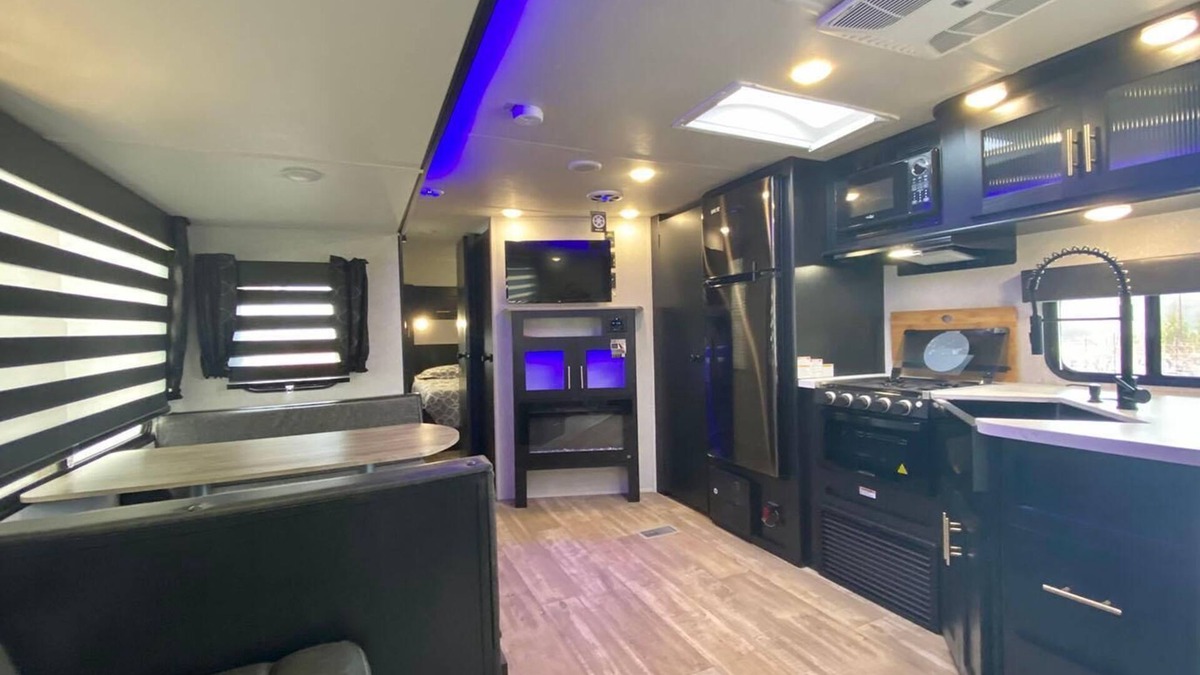 Talent House | Cherokee RV features a queen-sized bed, dining area, and full kitchen.