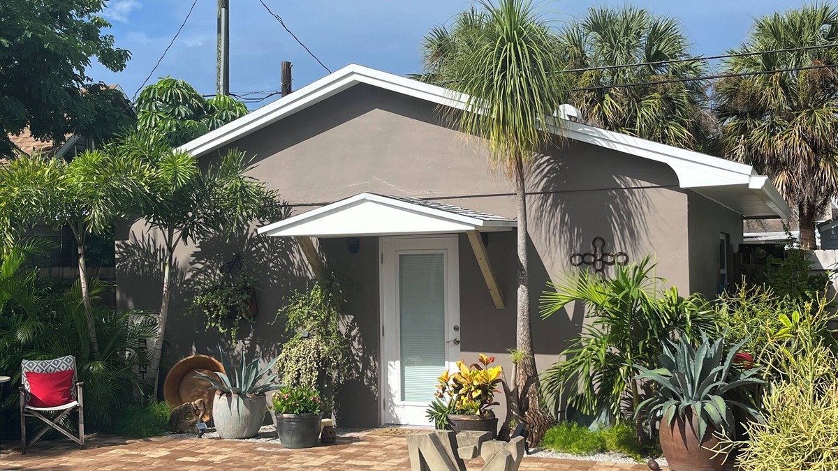 Parrot Cove Cottage | Chill on the patio overlooking the pool & lush gardens & grill your dinner!