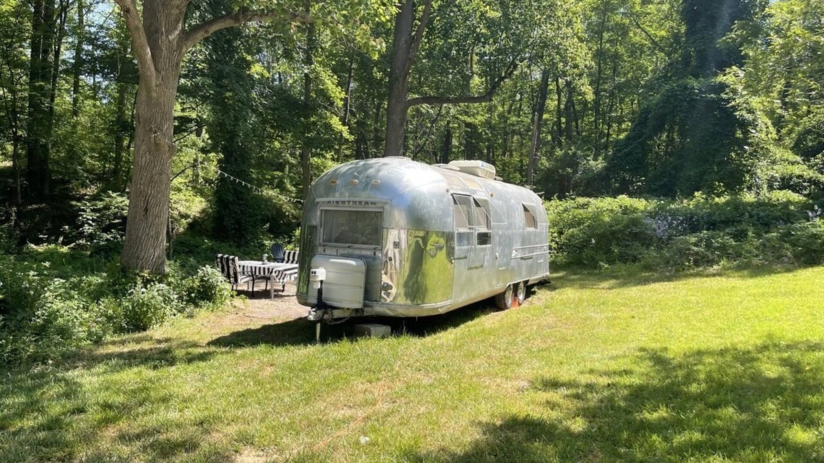 Changewater RV Rental | Modern Styled Vintage Airstream Nestled by a Stream on a Picturesque Tree Farm