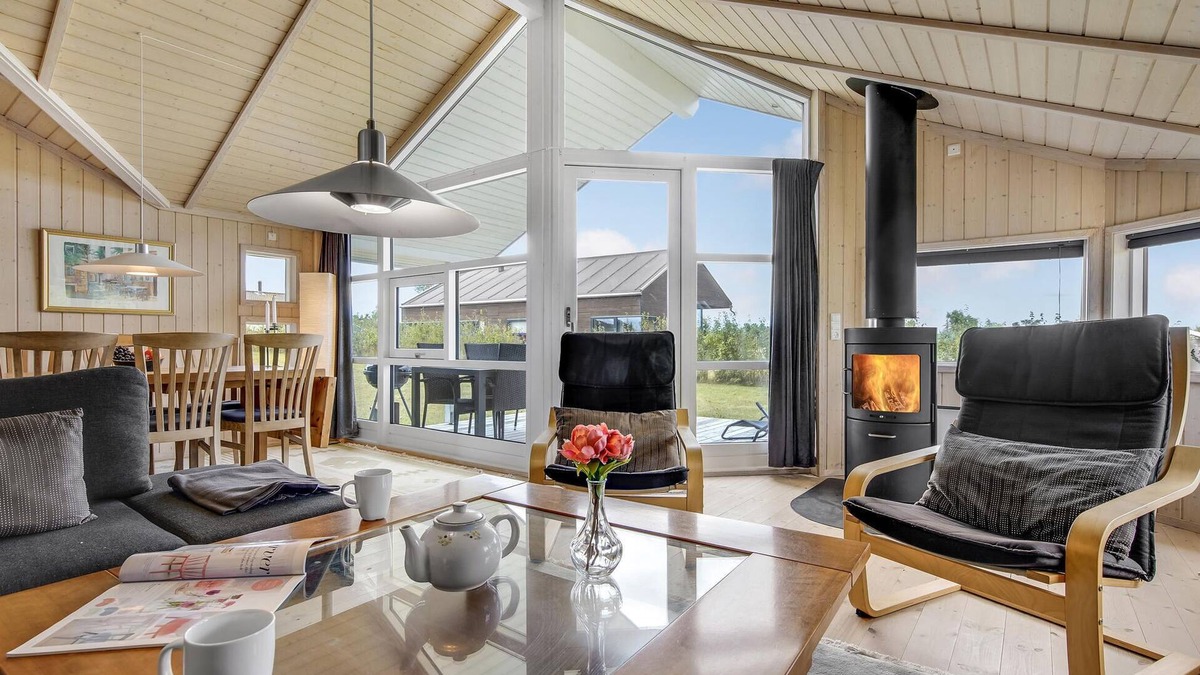 Havnsø House | The cottage has an inviting kitchen-living room with a fireplace and a partially covered terrace.