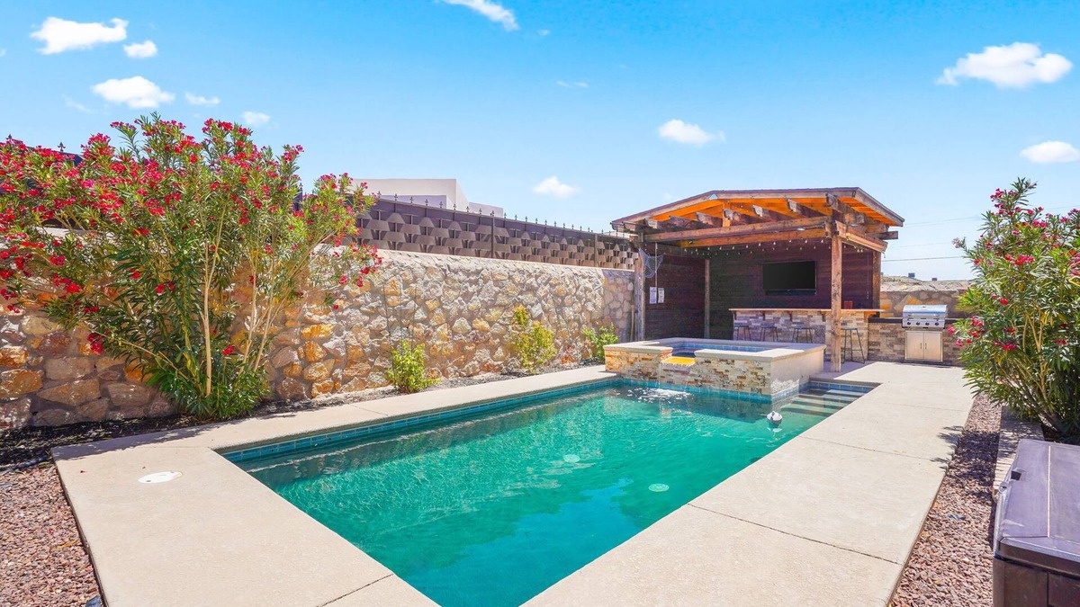 Biggs Field House | This is a true retreat in El Paso with a sparkling pool (w heater), hot tub, and full outdoor entertaining area with a 55" smart TV, tiki bar, and grill.