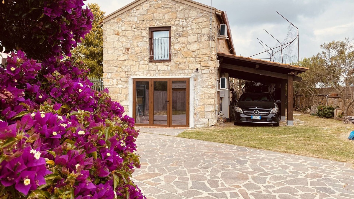 San Giovanni Suergiu Villa | Villa with garden, large windows, exposed beams and stones