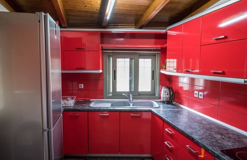 Porto Heli Cottage | A detached house which is embraced by green trees and beautiful flowers.