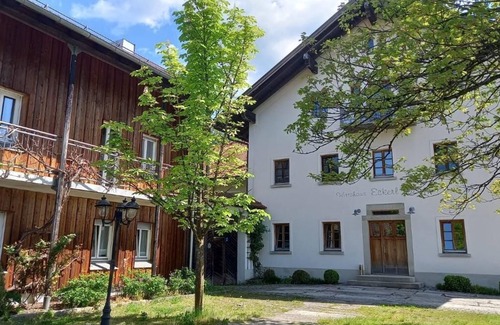 Bohmzwiesel Apartment | Ferienchalet mit überdachter Veranda mit Lounge Möbel und Schwebeliege.