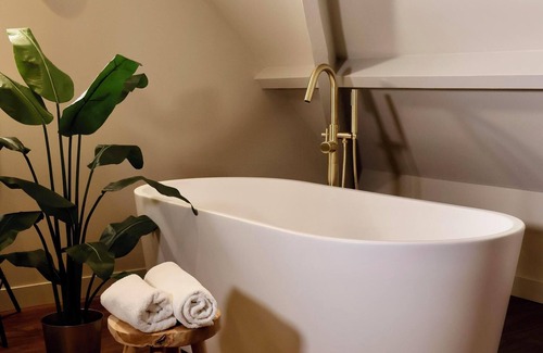 Appeltern Hotel | Luxurious family suite with river meadow views, a bathtub, and modern amenities for a relaxing family getaway.