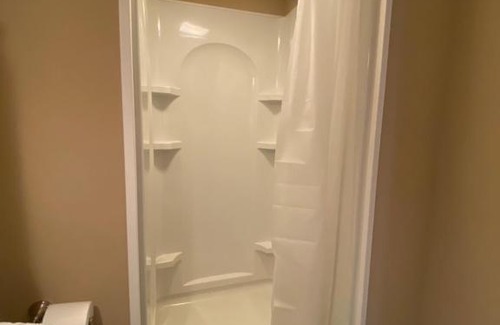 Maxwell House | Private basement bedroom with private bathroom, kitchen, and living room with large screen television