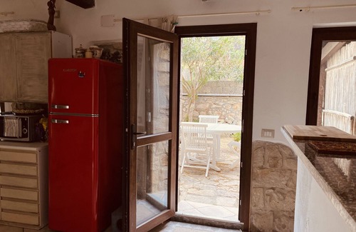 San Giovanni Suergiu Villa | Villa with garden, large windows, exposed beams and stones
