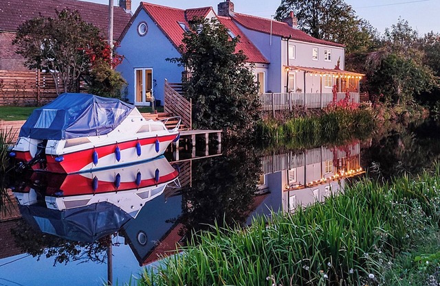 A charming riverside cottage in Upwell, accommodating up to 10 guests.