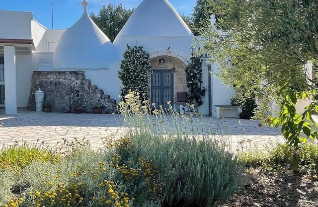 An ancient Trullo surrounded by olive trees with a gorgeous saltwater pool