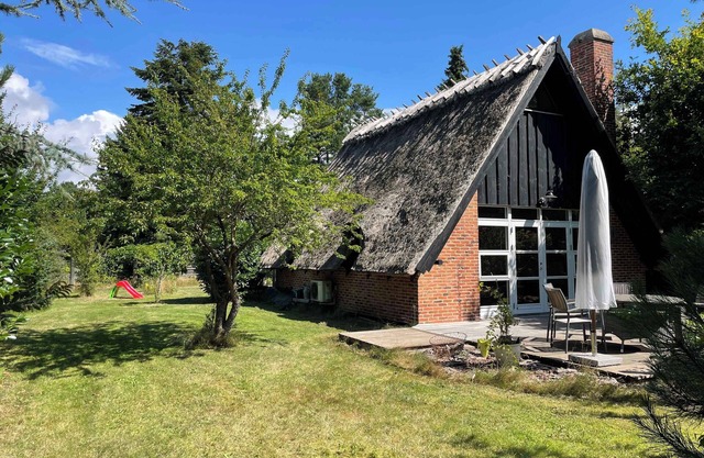 Charmerende sommerhus med stråtag tæt ved vandet