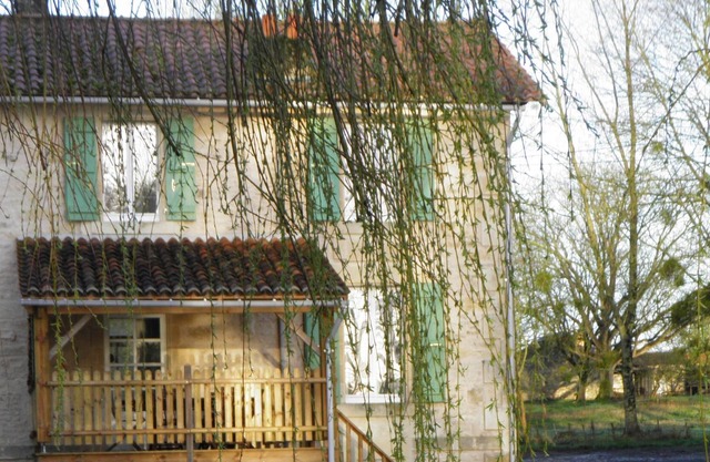 Cottage adjoining another cottage, with a view of a pond in the Vendée bocage