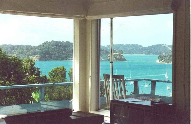 Iconic New Zealand beach cottage with elevated harbour and bush views.