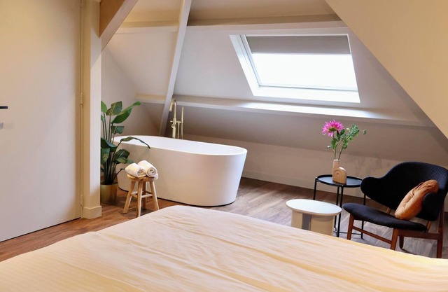 Luxurious family suite with river meadow views, a bathtub, and modern amenities for a relaxing family getaway.