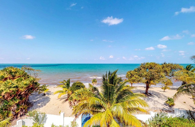 Ocean-view home with balcony, beach access, outdoor dining area & partial AC