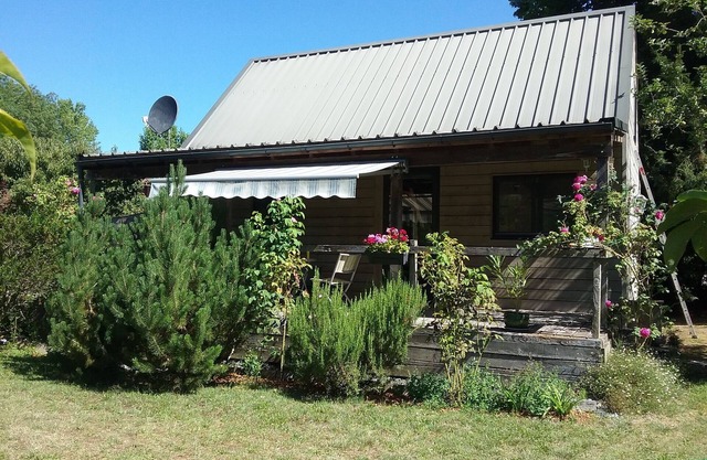 Small detached wooden house in well-maintained fenced park.
