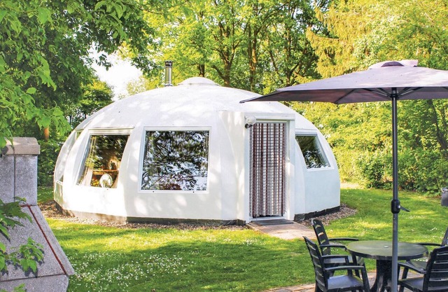 These detached bungalows with domed roofs are scattered in a wooded resort.