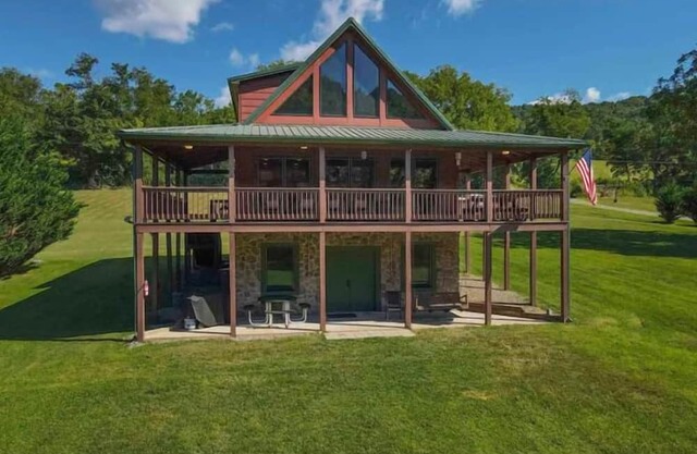 Sunny riverside cabin with loft views, big deck, game room, porches, and open lawn.